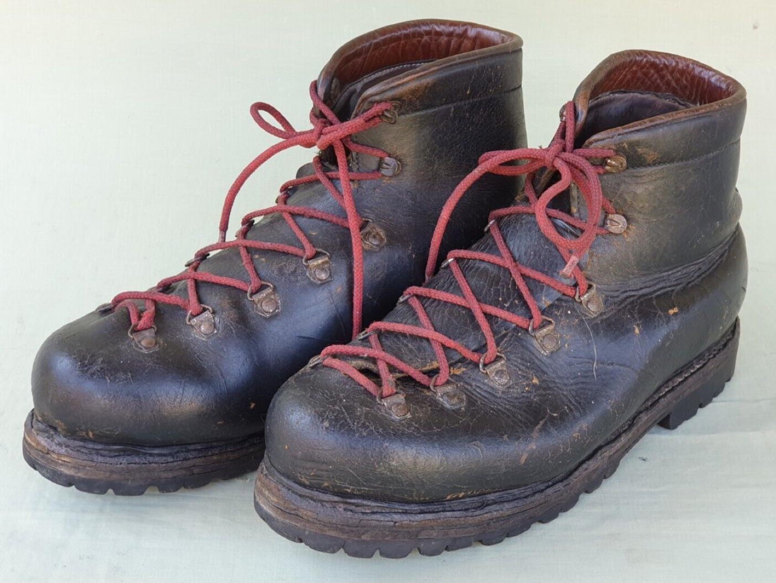 Vintage leather mountaineering boots with red laces and a Carrarmato-style rubber lug sole