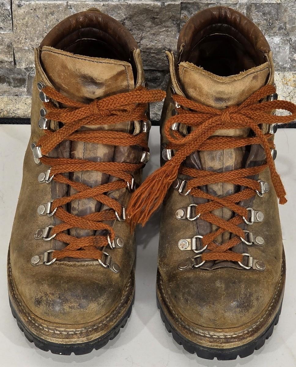 Pair of oiled leather trekking boots seen from above, with orange laces and a Vibram sole